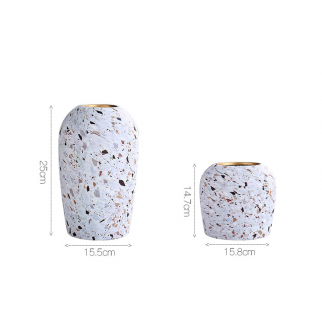 A ceramic vase with an arrangement of dried flowers in a corner of the living room.